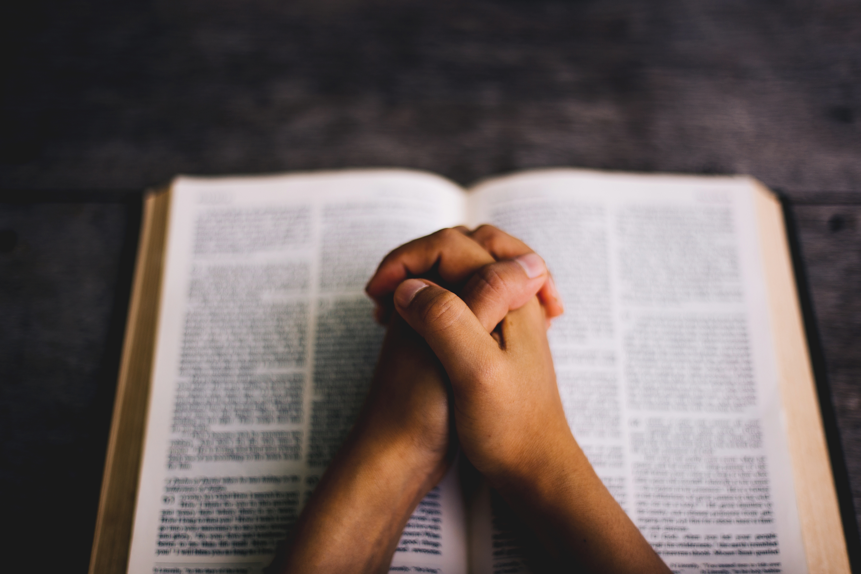 Praying hands on a bible
